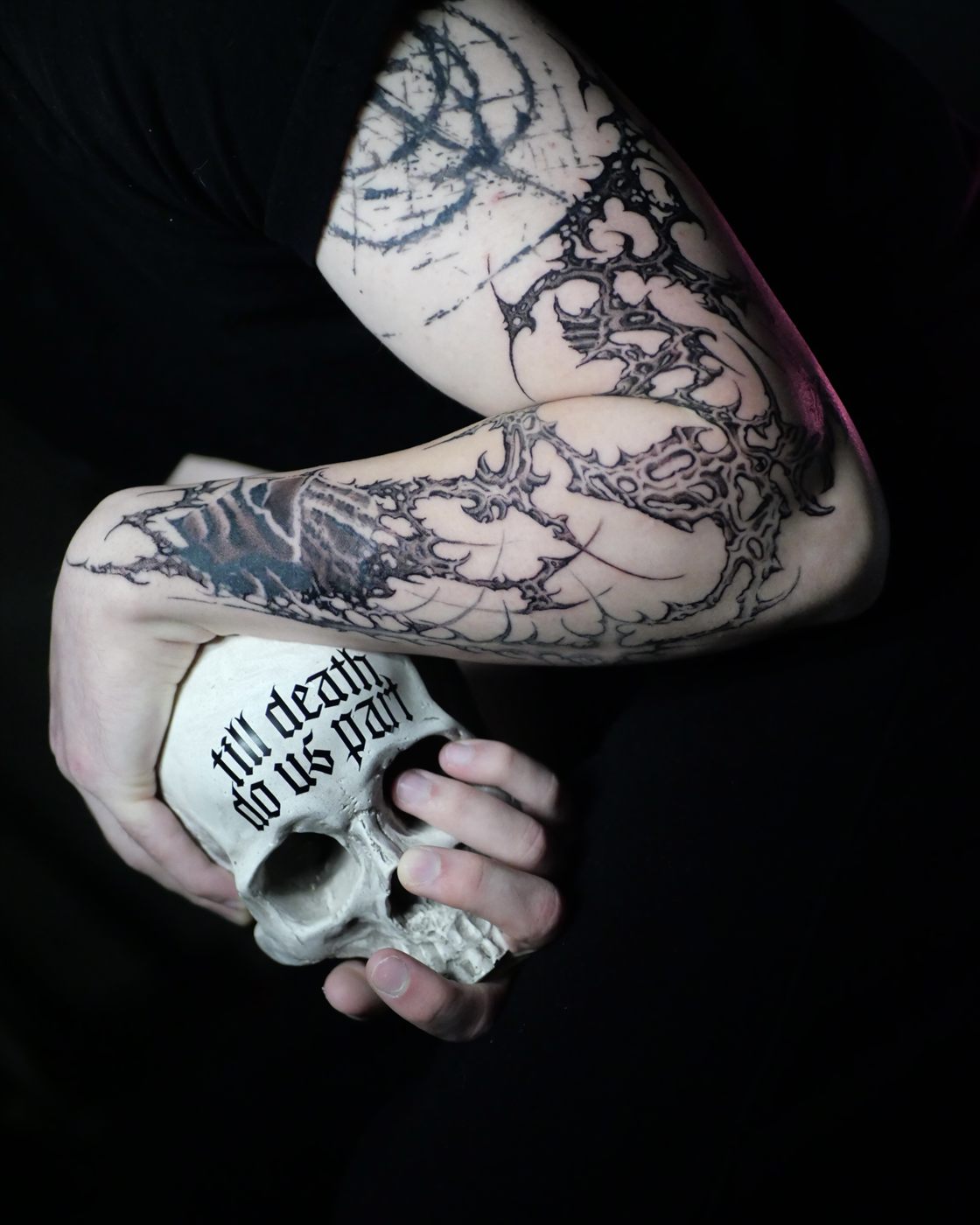 Detalle de manga ornamental gótica con calavera entre las manos